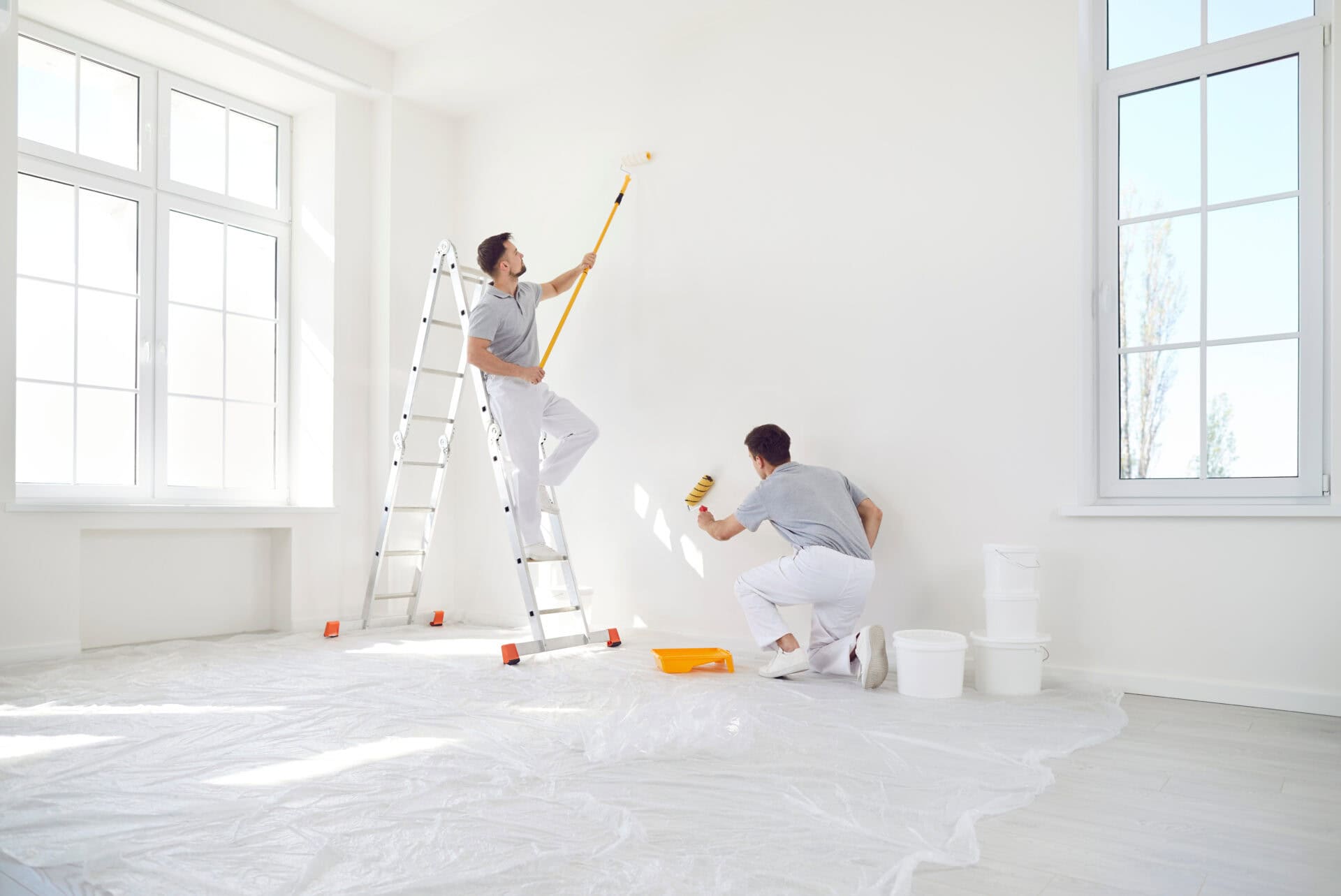 Interior painting in Woodstock, GA — floors covered and walls being rolled