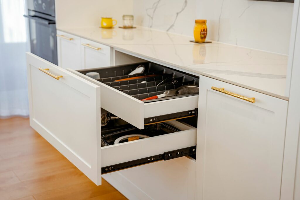 An open drawer in a fitted kitchen cabinet run