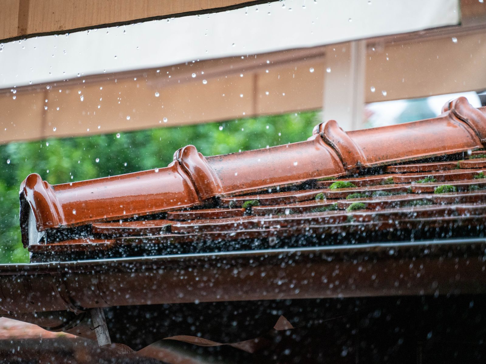 Gutter cleaning in Woodstock, GA — a gutter full of leaves with water running over it